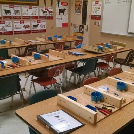 Empty classroom with desktops filled with electrical wiring supplies ready for students.