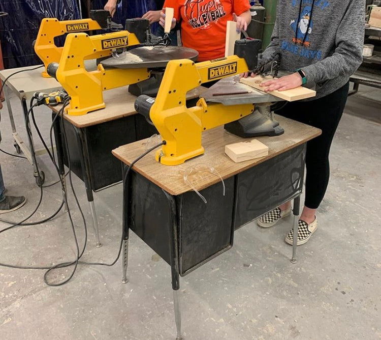 Students carefully cut wood using one of three scroll saws placed on desks in the Ag classroom.