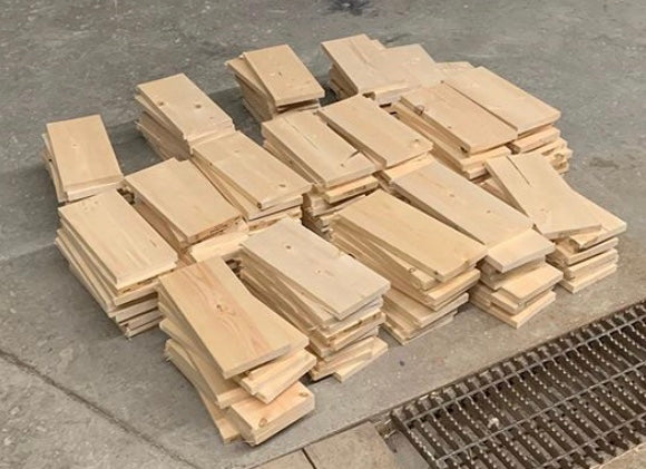 Multiple stacks of pre-cut lumber sit on a shop floor waiting for students and their imagination.